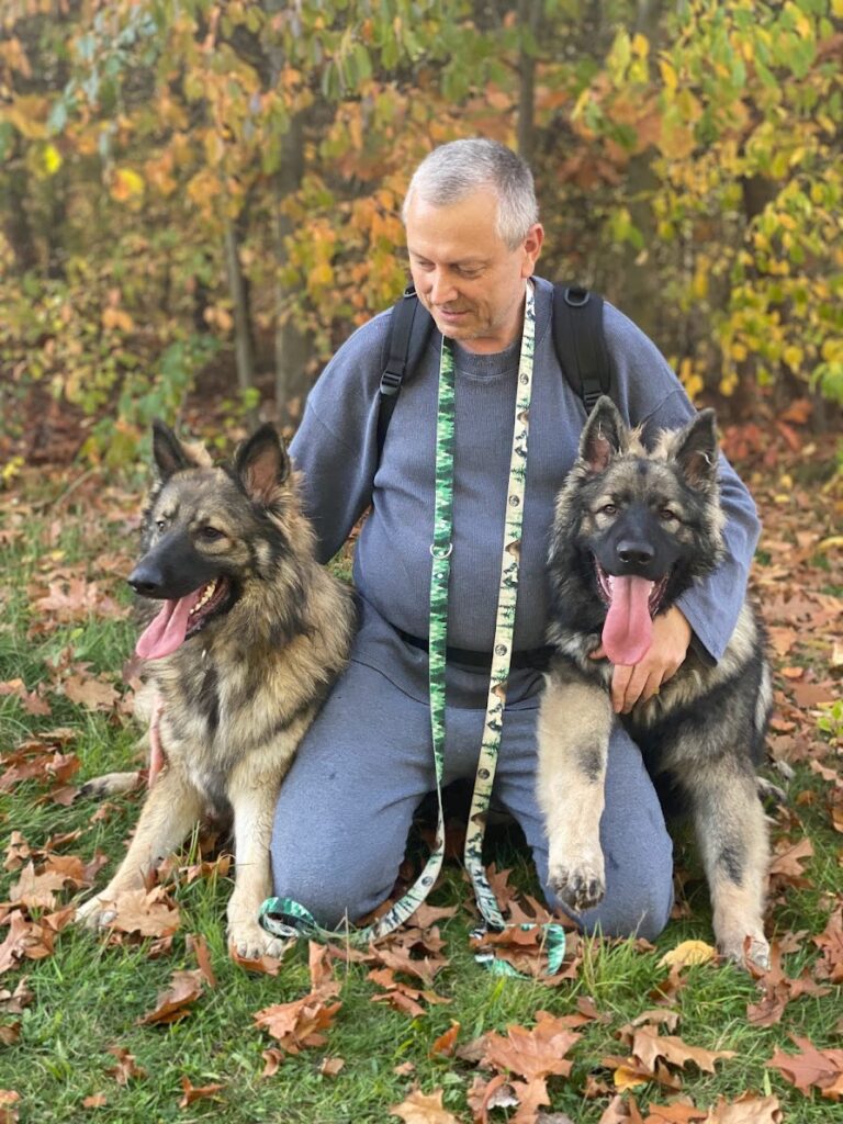 Właściciel ze swoimi dwoma owczarkami staroniemieckimi na spacerze